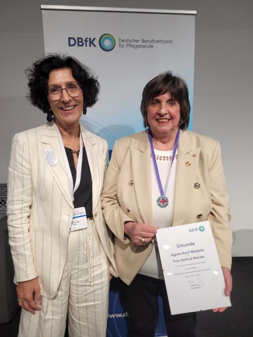 Vera Lux (l.) überreichte Gertrud Stöcker die Agnes Karll Medaille, die höchste Auszeichnung des DBfK.